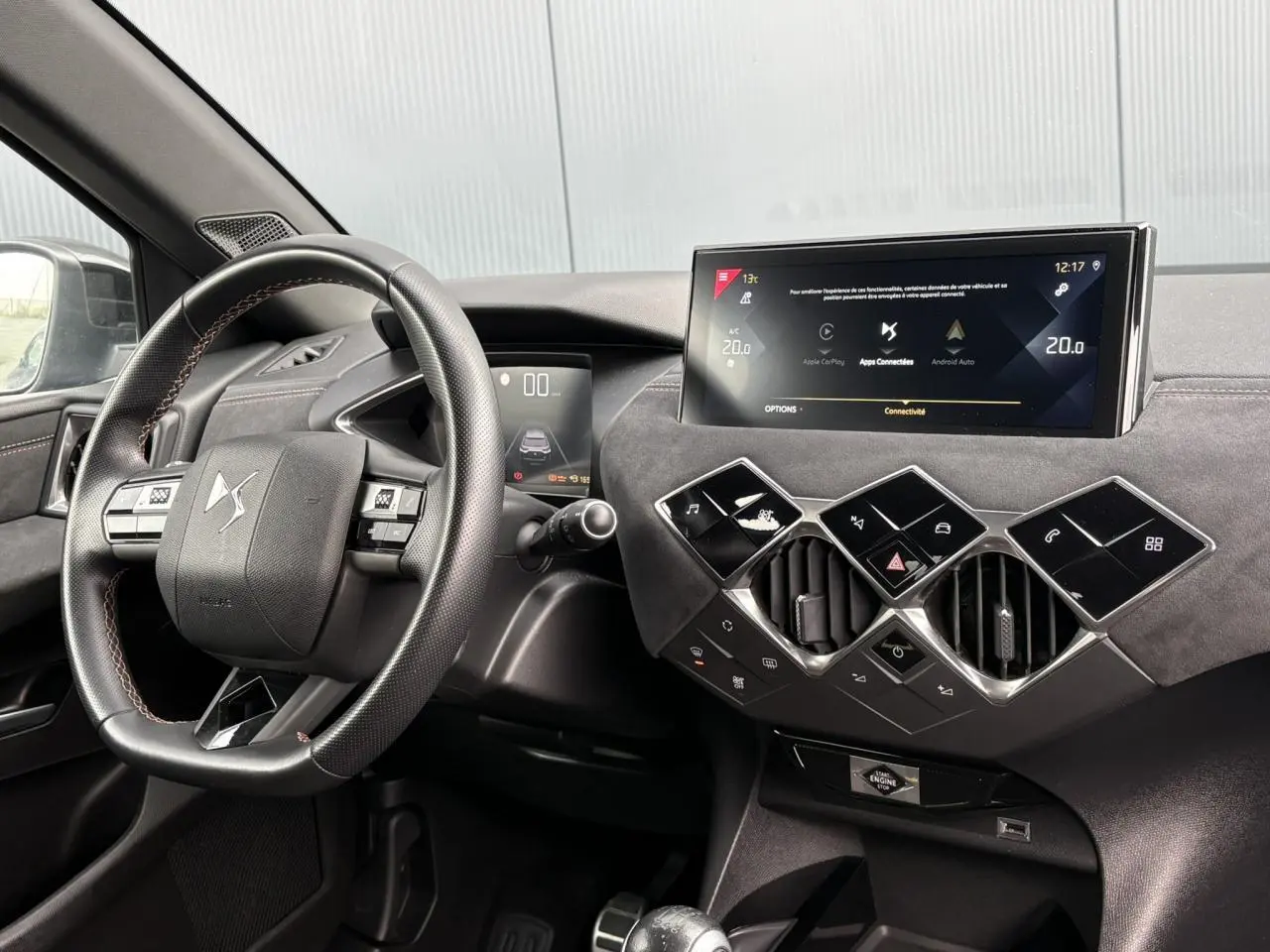 Vue intérieure du tableau de bord et volant en cuir multifonction du DS3 Crossback gris Artense avec écran tactile central.