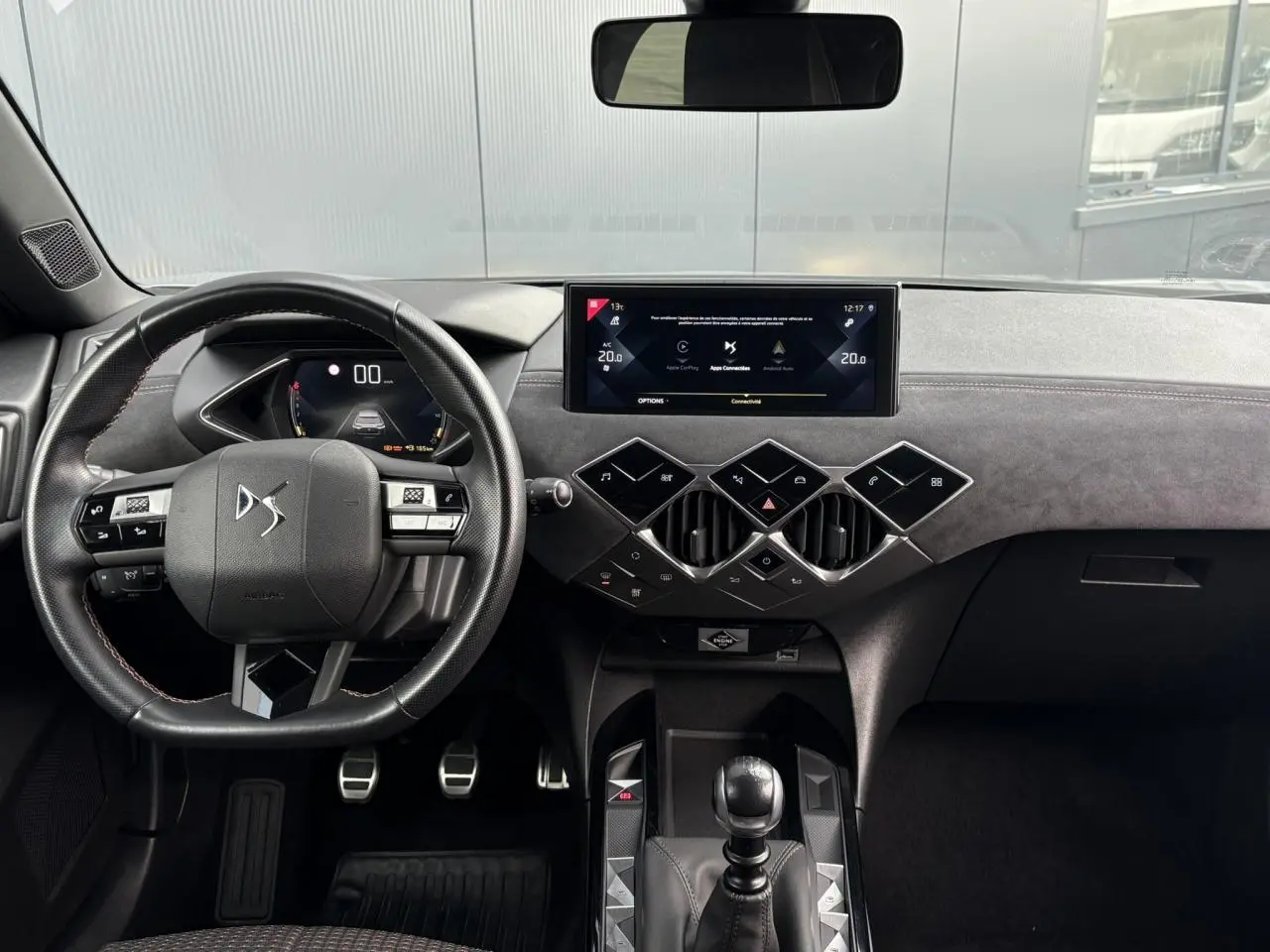 Vue intérieure frontale du tableau de bord du DS3 Crossback gris Artense, volant cuir multifonction et écran tactile central.