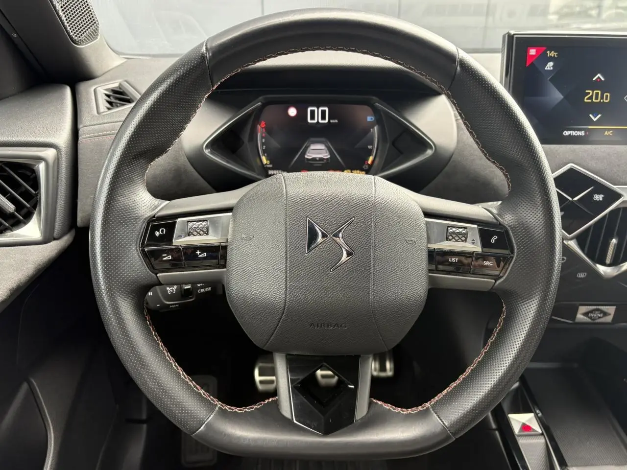 Vue rapprochée du volant en cuir noir avec logo DS, tableau de bord numérique et écran tactile du DS3 Crossback.