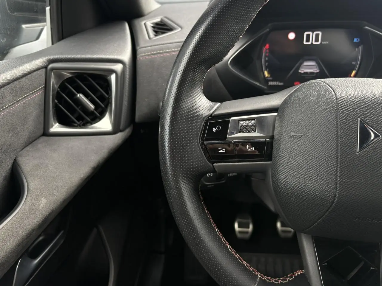 Vue rapprochée du volant en cuir noir avec commandes multifonctions et tableau de bord numérique du DS3 Crossback.