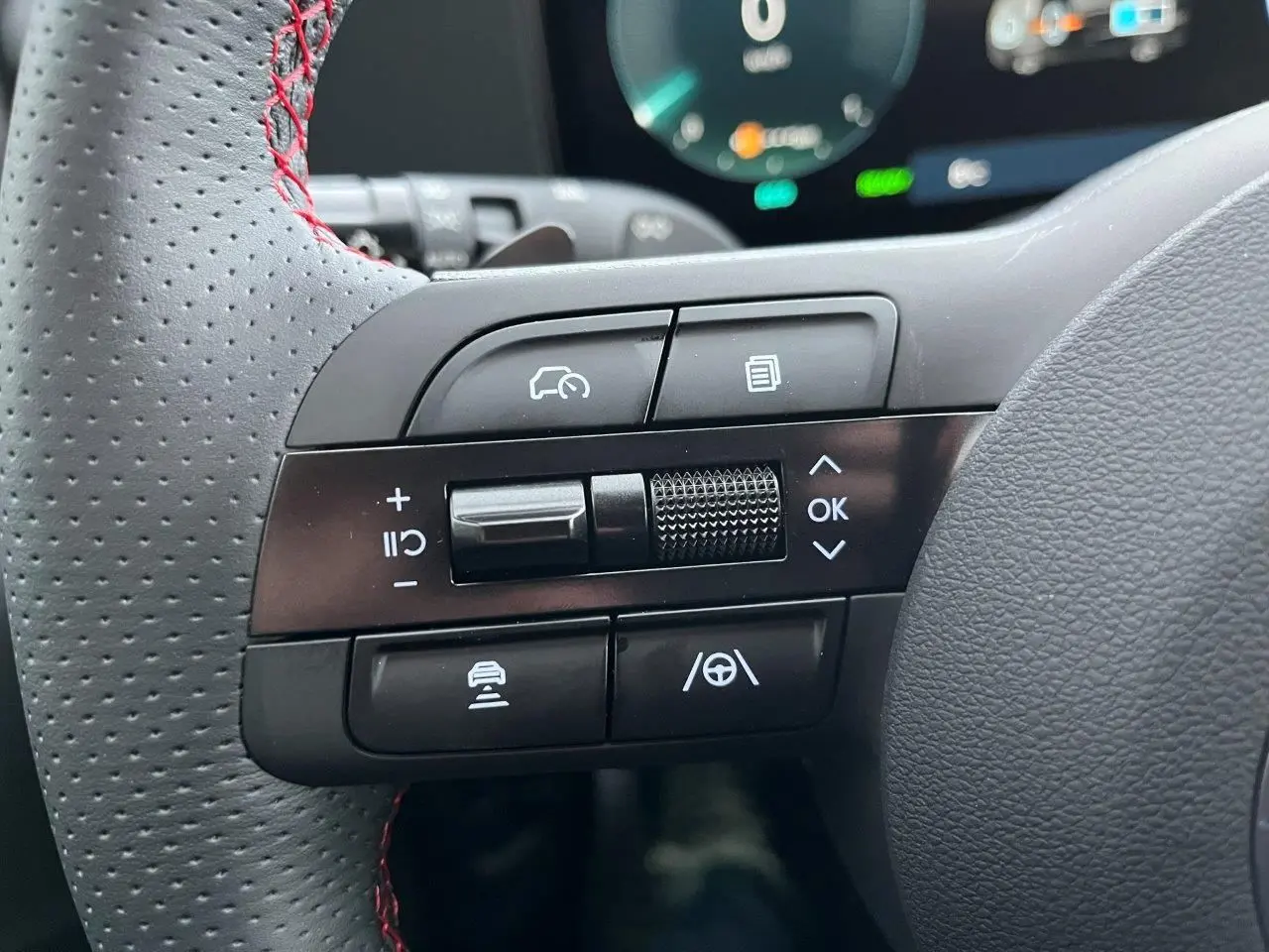 Gros plan sur les commandes multifonctions à gauche du volant perforé avec surpiqûres rouges du Hyundai Tucson 2025 finition N-Line.