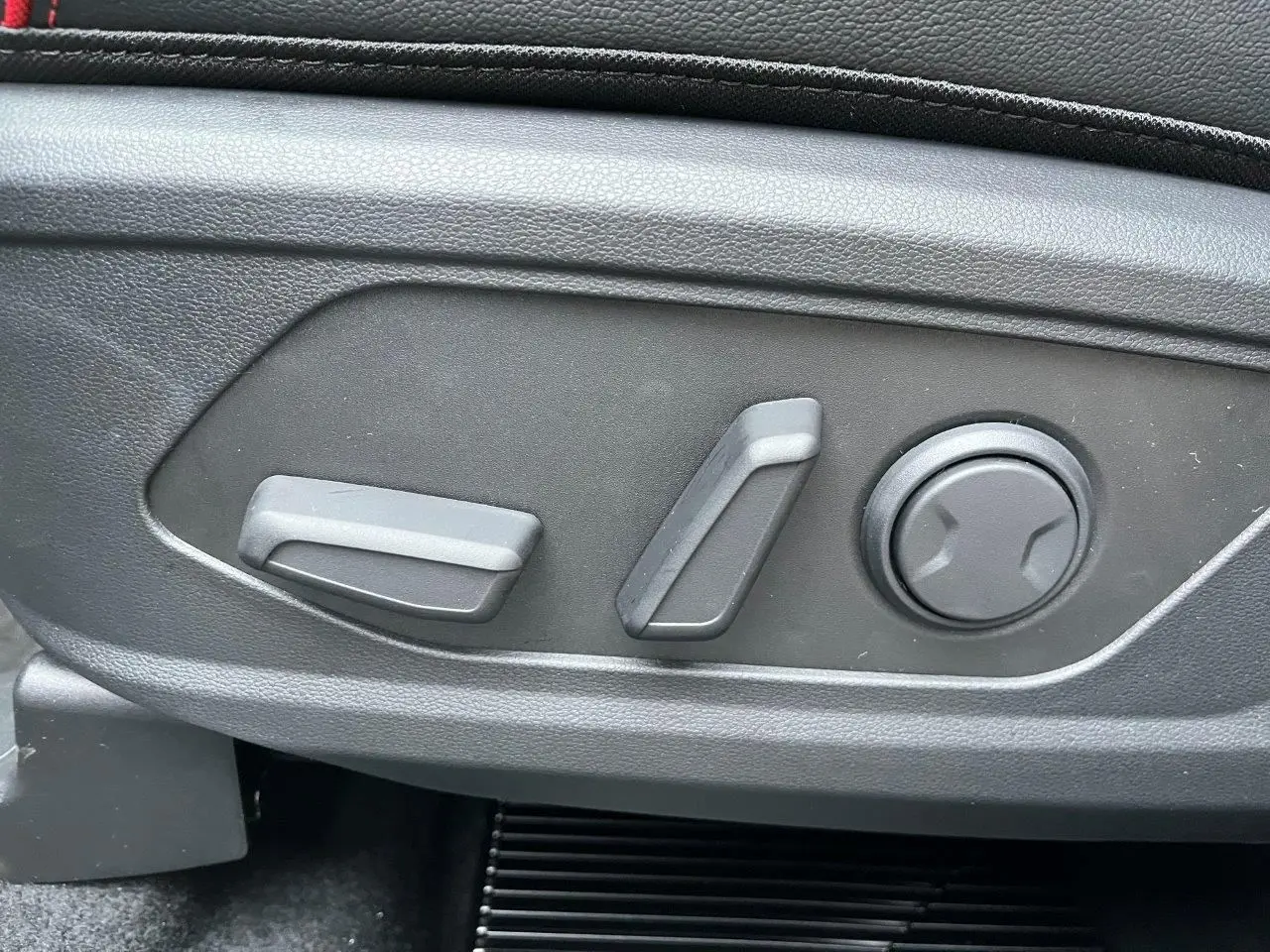 Gros plan sur les commandes de réglage électrique du siège côté conducteur d’un Hyundai Tucson 2025 noir abyss.