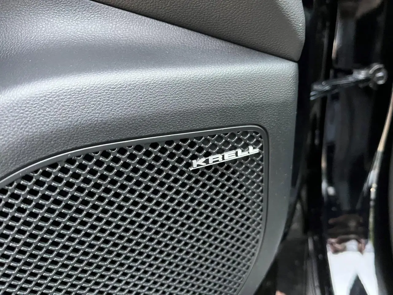 Gros plan sur le haut-parleur Krell intégré dans la porte intérieure noire du Hyundai Tucson 2025 Abyss Black.