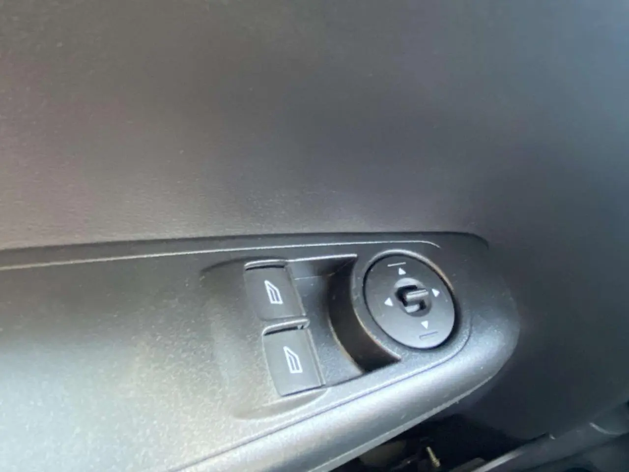 Détail des commandes électriques des vitres et des rétroviseurs côté conducteur du Ford Tourneo Courier blanc 2022.