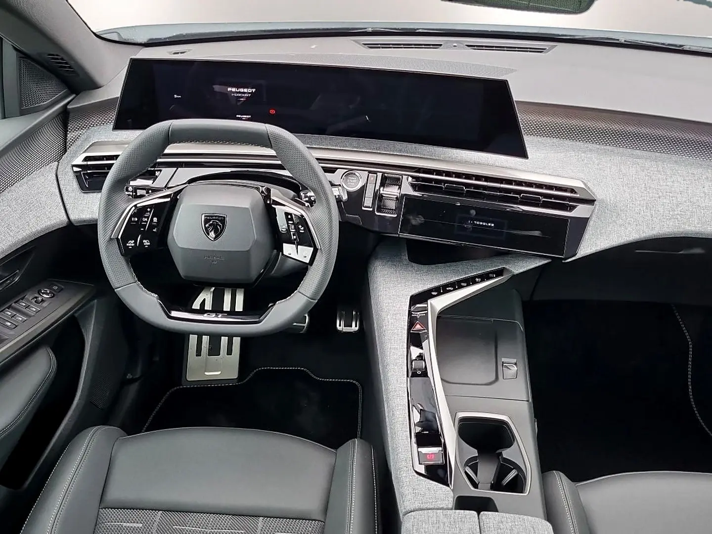 Vue intérieure avant du Peugeot 3008 1.2 hybrid 145 GT e-DCS6, volant cuir et tableau de bord moderne gris clair.