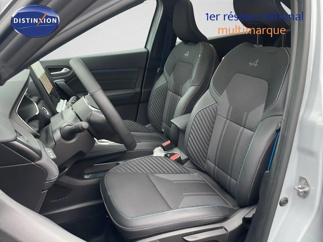 Intérieur côté conducteur de la Renault Symbioz 2025 avec sièges noirs et logo Alpine brodé sur les appuie-têtes.