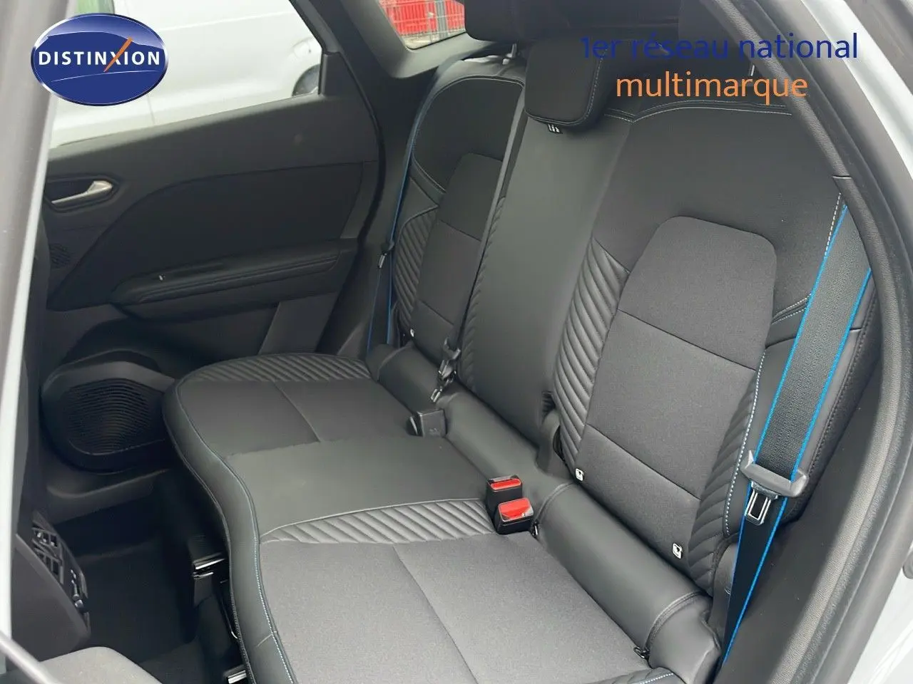 Vue intérieure sur les sièges arrière noirs avec surpiqûres bleues du Renault Symbioz gris Rafale Metal 2025.