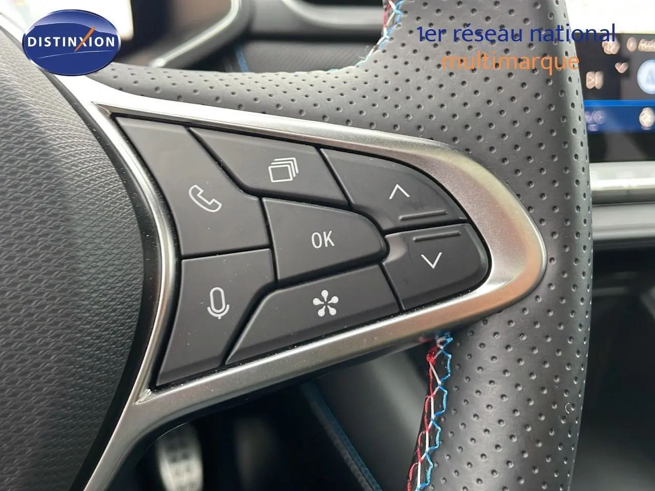 Gros plan sur les commandes multifonctions du volant perforé du Renault Symbioz gris Rafale Métal 2025.