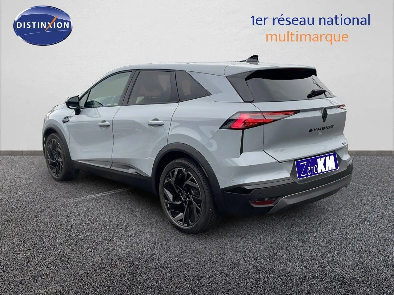 Renault Symbioz gris Rafale métal vu en 3/4 arrière droit avec jantes noires et feux arrière LED distinctifs.