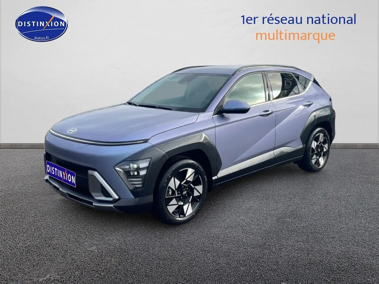 Hyundai Kona 2025 bleu en 3/4 avant droit avec jantes alliage et protections noires sur ailes et bas de caisse.