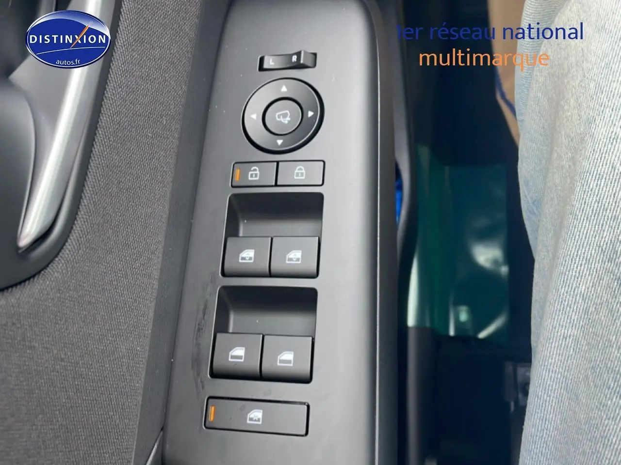 Vue rapprochée des commandes de lève-vitres et rétroviseurs sur la porte côté conducteur d'une Hyundai Kona bleu 2025.