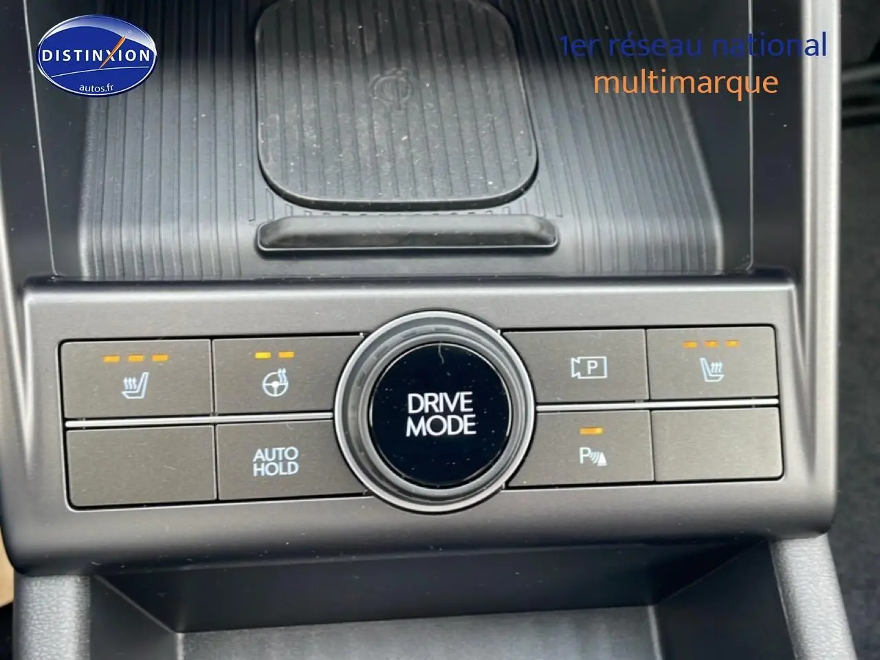 Gros plan sur la console centrale du Hyundai Kona bleu 2025, avec bouton Drive Mode et commandes chauffantes visibles.