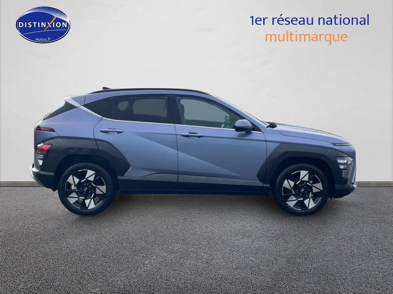 Vue de profil côté gauche du Hyundai Kona bleu 2025 avec jantes alliage et protections noires sur les ailes.