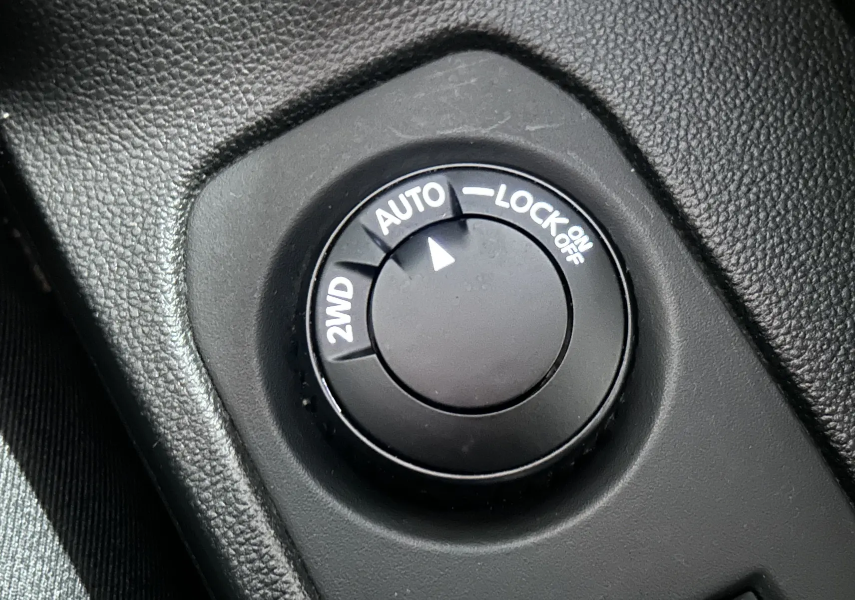 Gros plan sur le sélecteur de mode 4x4 du Dacia Duster 2023, bouton noir avec options 2WD, Auto et Lock.