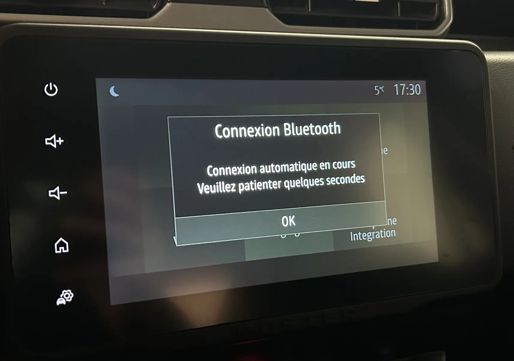 Écran tactile central du Dacia Duster 2023 affichant une connexion Bluetooth en cours, avec commandes tactiles sur le côté gauche.