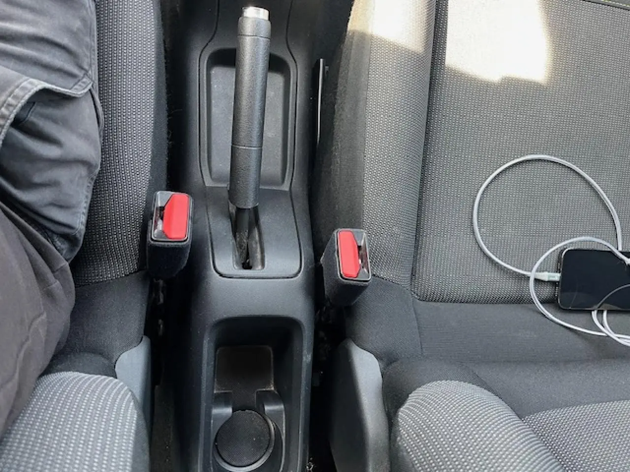 Vue intérieure centrée sur la console centrale et les sièges avant gris foncé de la Citroën C3 2023.