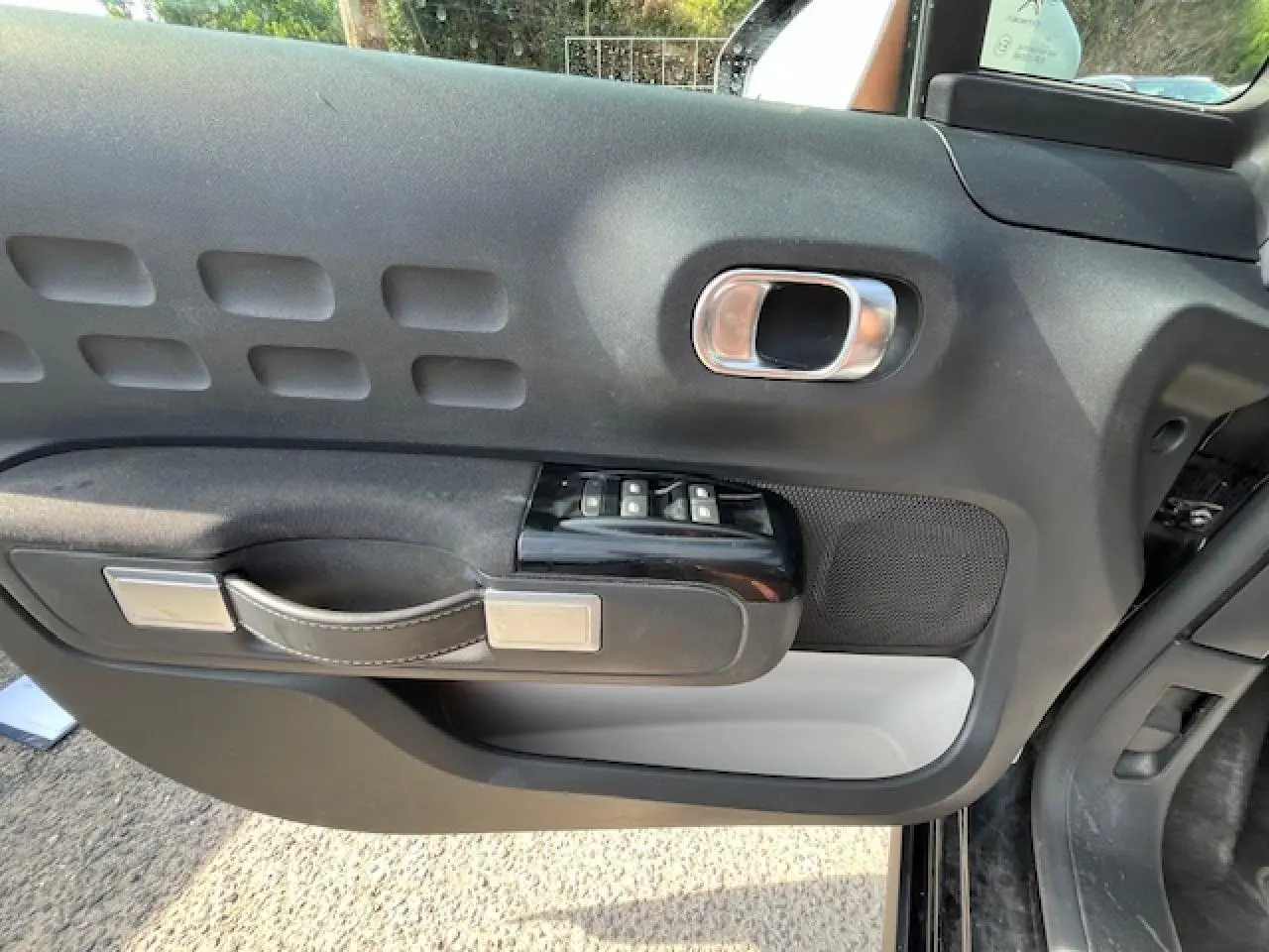 Vue rapprochée de la porte avant gauche noire de la Citroën C3 2023, avec commandes de vitres et poignée design.