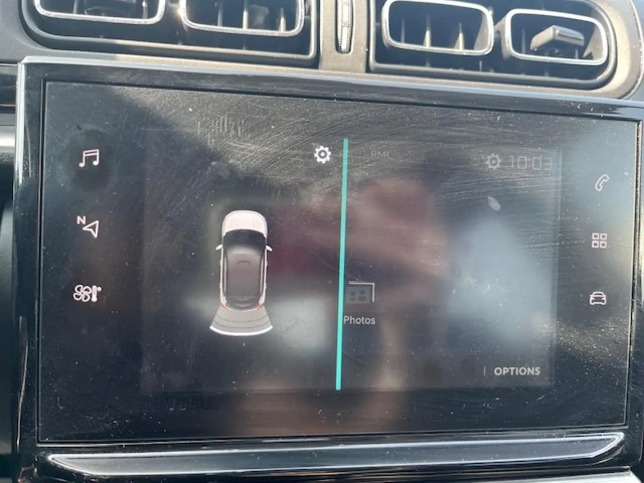 Écran tactile intérieur montrant l'aide au stationnement avec vue aérienne d'une Citroën C3 noire.