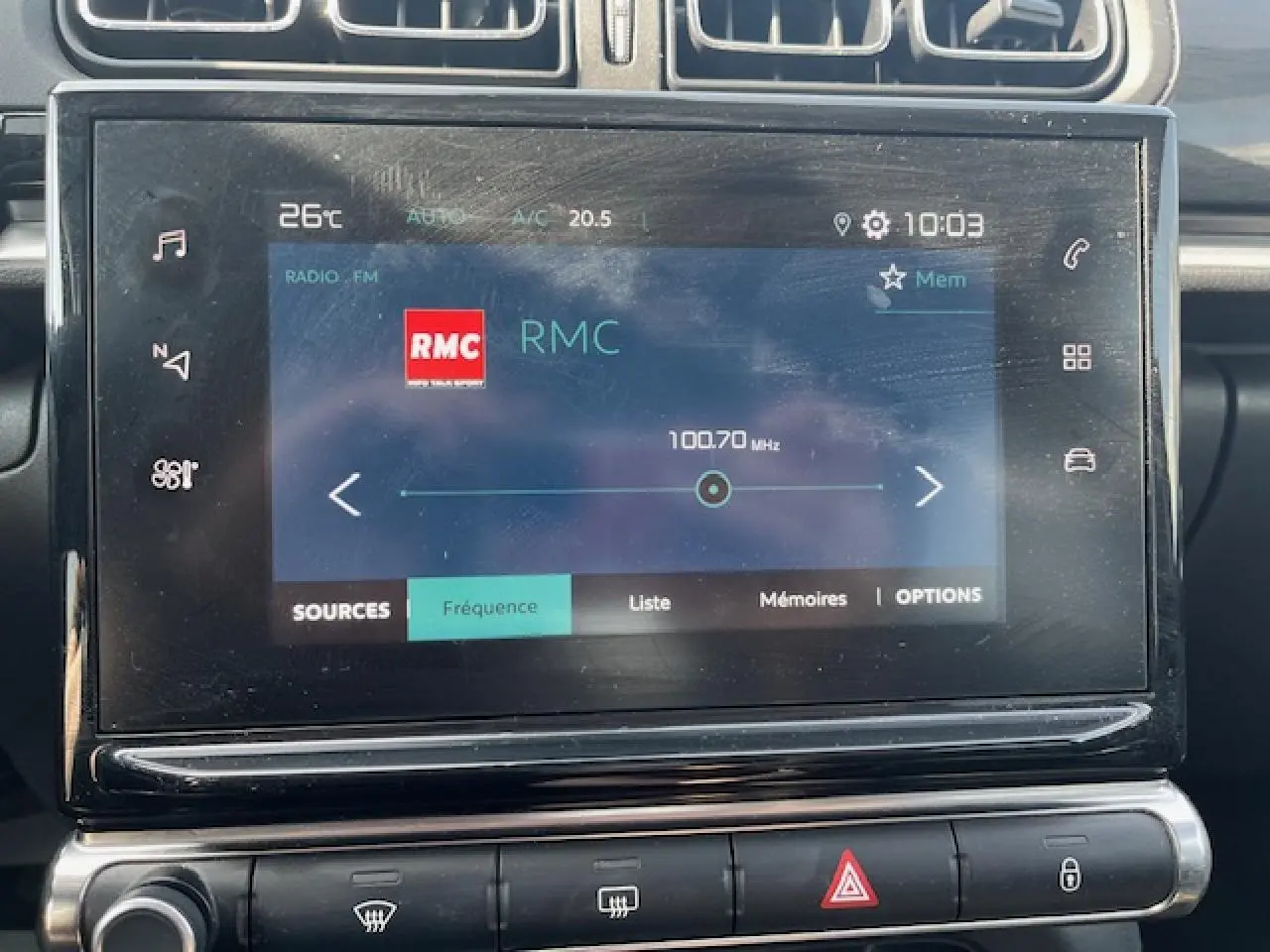 Gros plan sur l’écran tactile central de la Citroën C3 2023 affichant la radio RMC en mode FM.