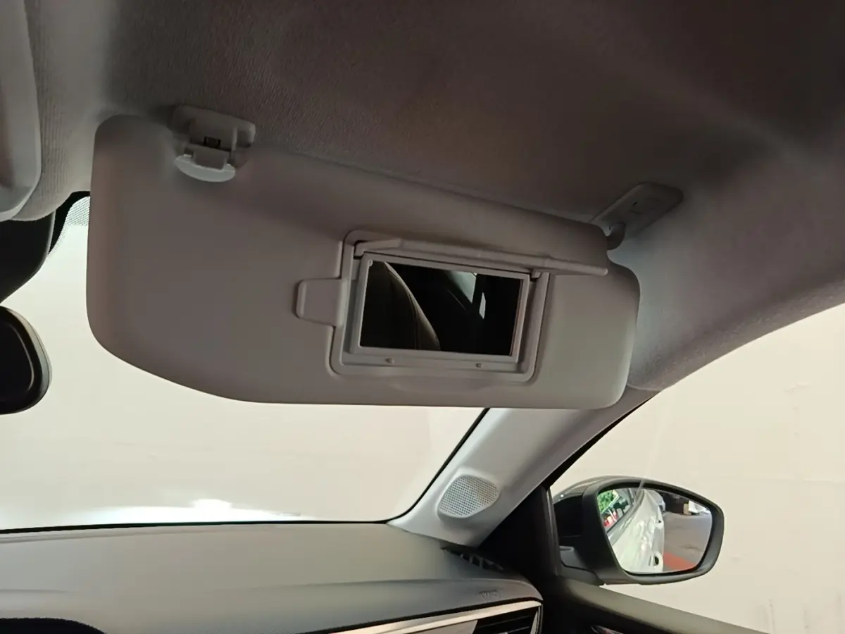 Détail intérieur du pare-soleil avec miroir ouvert côté conducteur de l’Opel Corsa blanc, vue depuis l’habitacle.