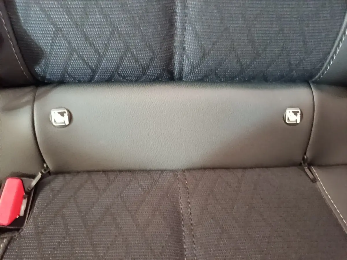 Gros plan sur la banquette arrière noire de l'Opel Corsa avec fixation Isofix et ceinture rouge visible à gauche.