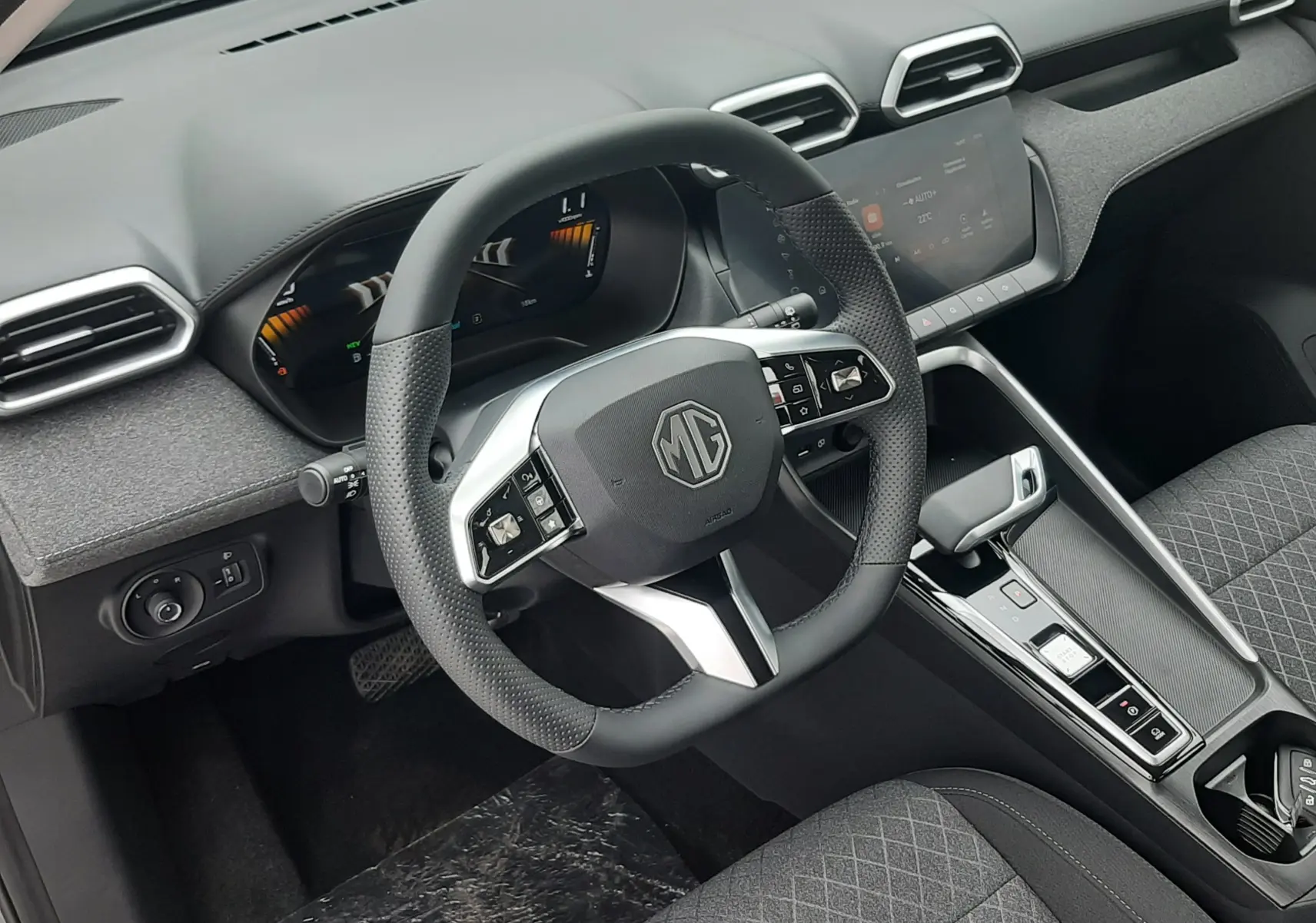 Vue intérieure du poste de conduite MG ZS 1.5 HYBRID+ 2026, volant multifonction noir et tableau de bord moderne gris Camden Grey.