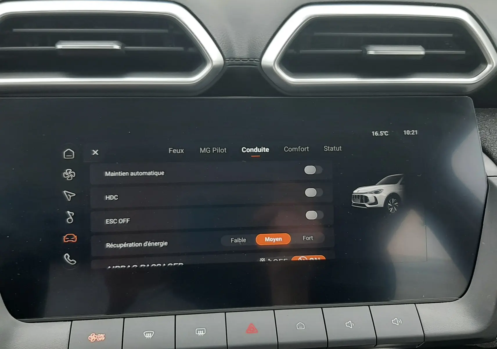 Écran tactile central du MG ZS 1.5 Hybrid+ 2026 en vue frontale, affichant les réglages de conduite, avec aérateurs hexagonaux au-dessus.