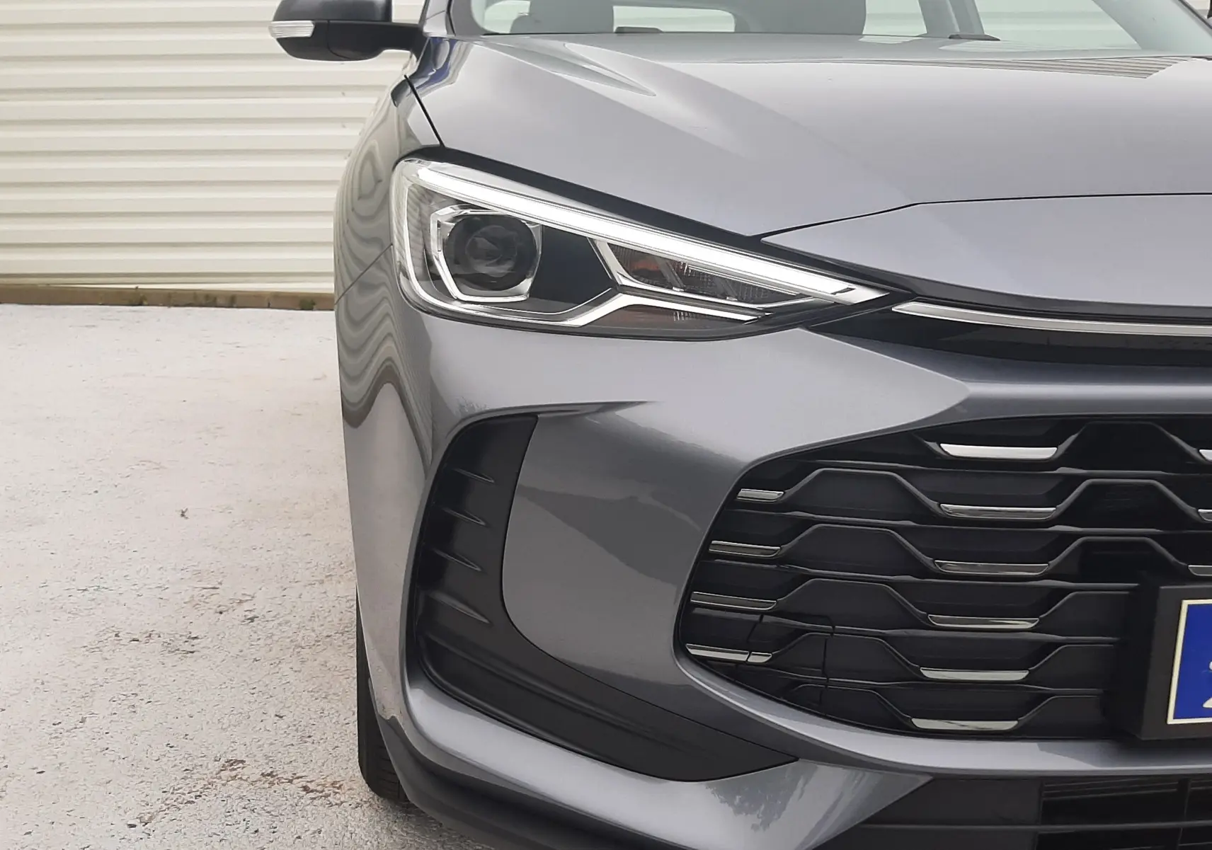 Vue avant gauche rapprochée du MG ZS Camden Grey 2026, mettant en valeur ses phares LED et la calandre noire distinctive.