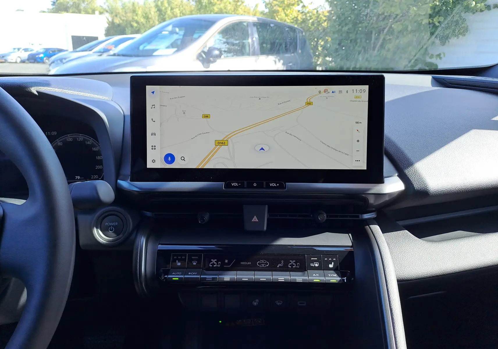 Vue centrée sur le volant noir du Toyota C-HR 2025 avec tableau de bord numérique et écran tactile à droite.