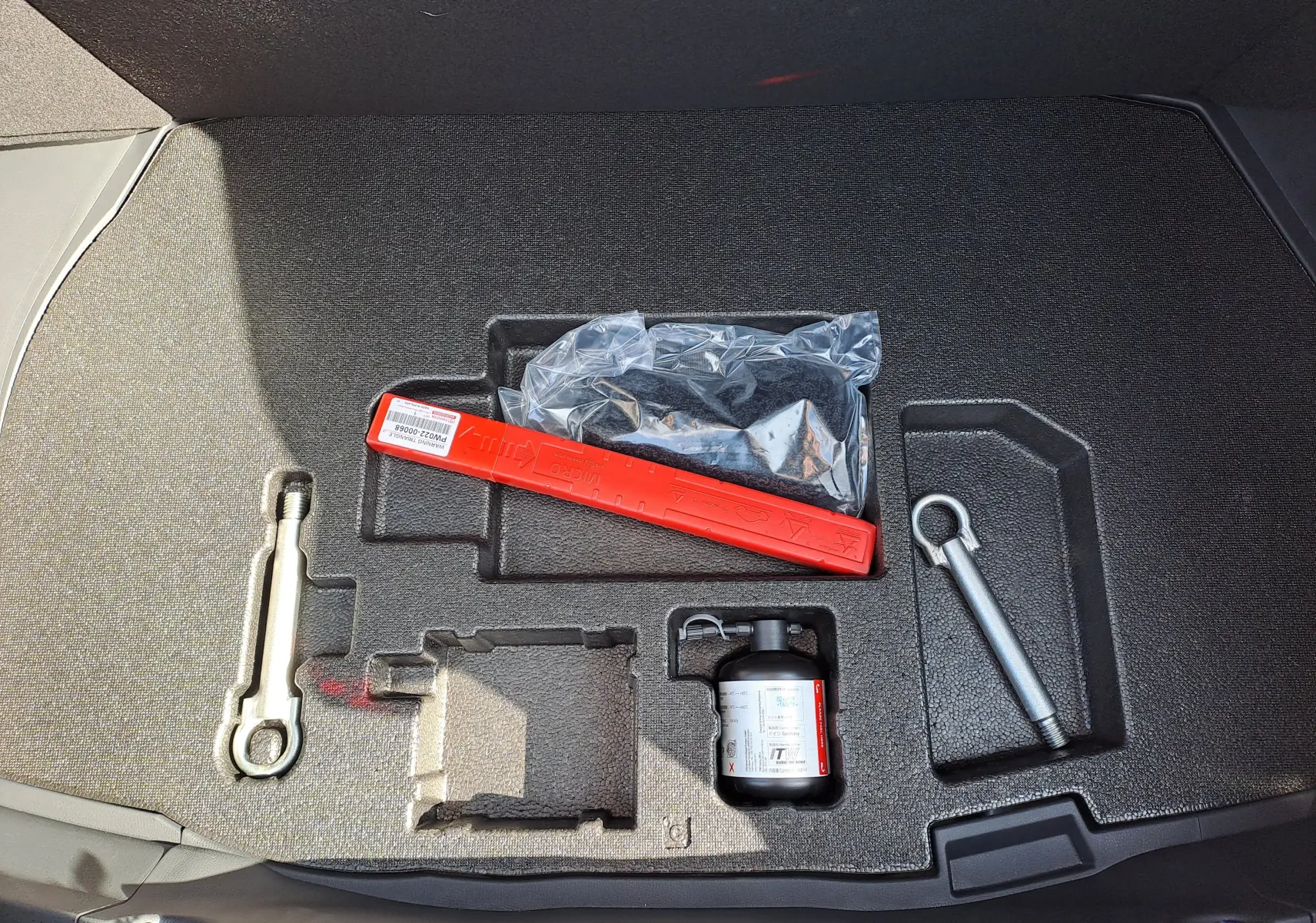 Vue plongeante sur la console centrale et les sièges avant noirs du Toyota C-HR gris minéral 2025 hybride avec boîte auto.