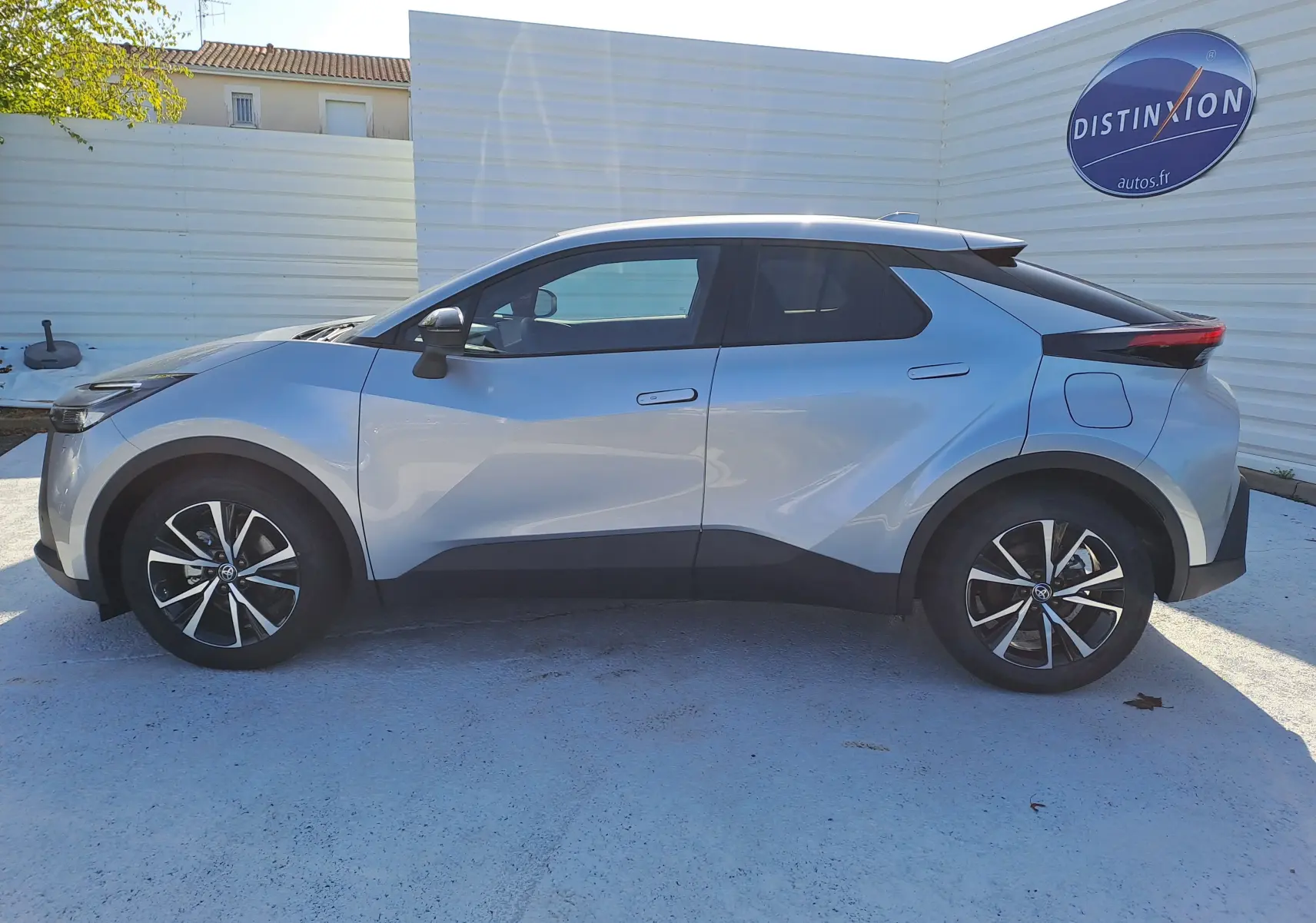 Toyota C-HR gris minéral vu 3/4 arrière droit, avec feux arrière LED et jantes bi-ton 18 pouces.