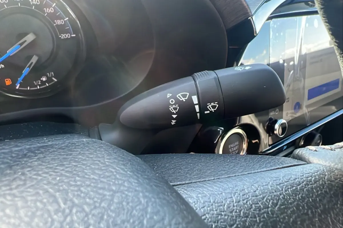 Gros plan sur la commande d'essuie-glace et le tableau de bord noir du Toyota Hilux 2025 gris atlas, version Invincible.