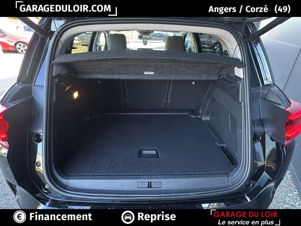 Coffre ouvert vu de l'arrière d'un Citroën C5 Aircross noir 2025, avec tablette cache-bagages et intérieur spacieux.