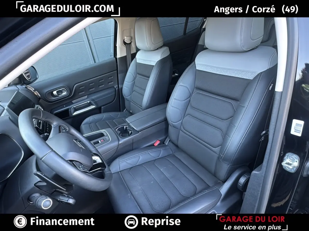 Intérieur du Citroën C5 Aircross noir, vue côté conducteur, sièges cuir noirs avec surpiqûres grises et volant multifonctions.