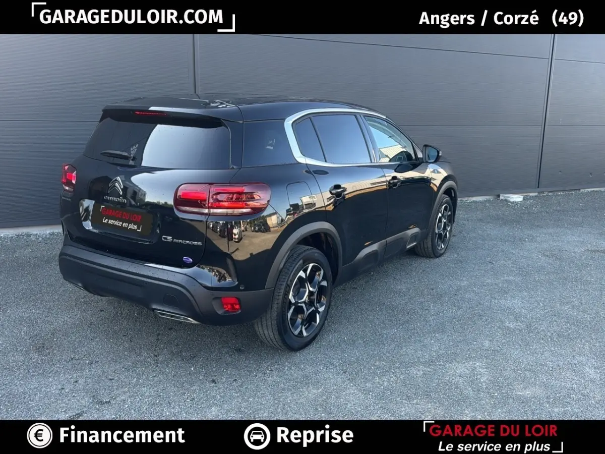Vue 3/4 arrière droite d'un Citroën C5 Aircross noir 2025, avec jantes distinctives et vitres teintées.