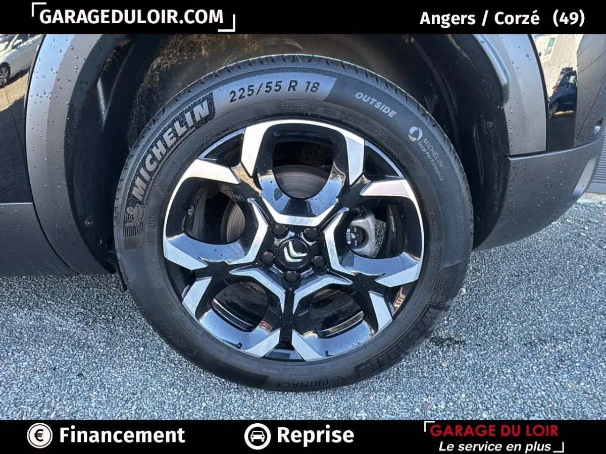 Gros plan sur la roue avant droite noire avec jante alliage bicolore du Citroën C5 Aircross noir 2025.