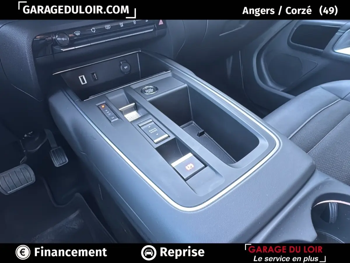 Vue intérieure centrée sur la console centrale noire du Citroën C5 Aircross 2025 avec commandes électroniques et rangements.