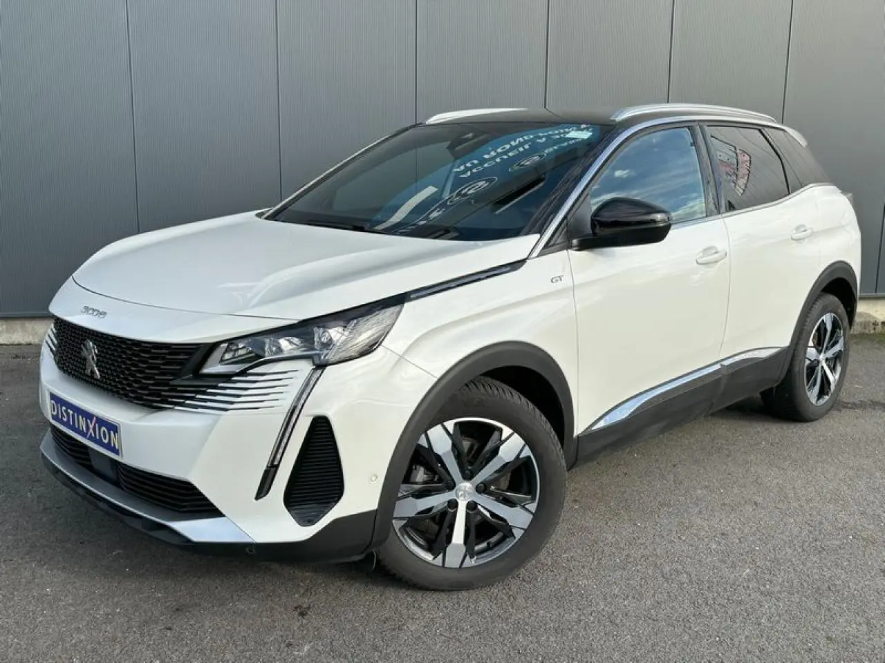 Peugeot 3008 GT blanc nacré en 3/4 avant droit, toit noir et jantes alliage bi-ton 18 pouces.