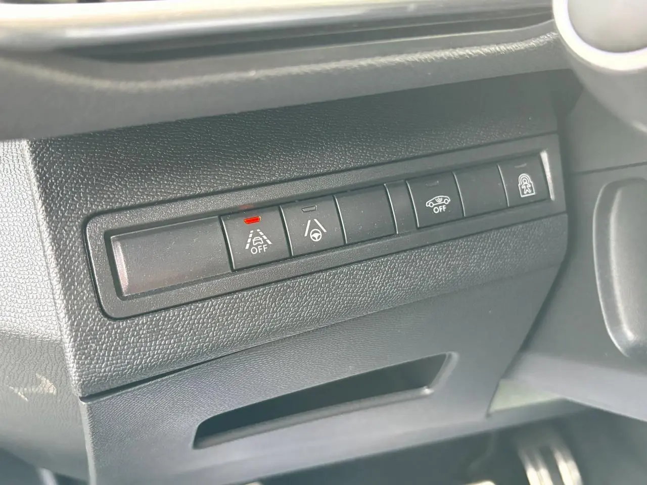 Gros plan sur les commandes d'aide à la conduite à gauche du volant dans l'habitacle du Peugeot 3008 blanc nacré 2024.