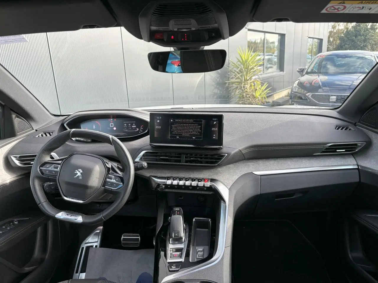 Vue intérieure avant du Peugeot 3008 2024, tableau de bord moderne avec écran tactile 10 pouces et volant compact cuir noir.