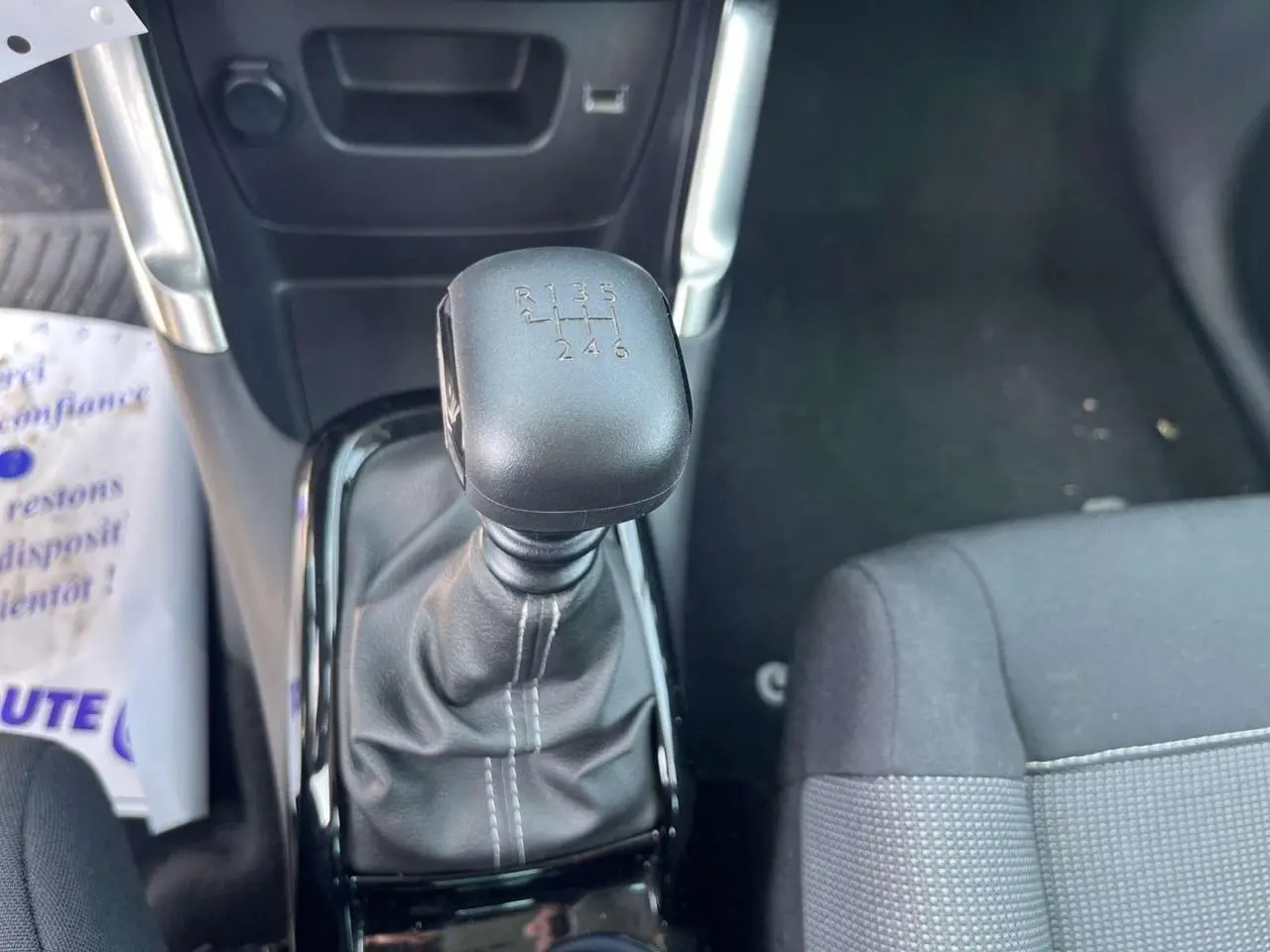 Gros plan sur le levier de vitesses manuel de la Citroën C3 Aircross 2023, intérieur noir avec coutures blanches.