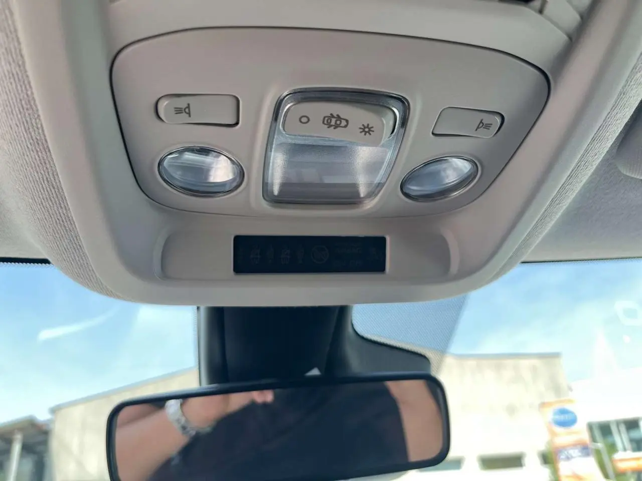 Vue intérieure en contre-plongée du plafonnier gris clair avec commandes d’éclairage et rétroviseur intérieur d’une Citroën C3 Aircross blanc banquise.