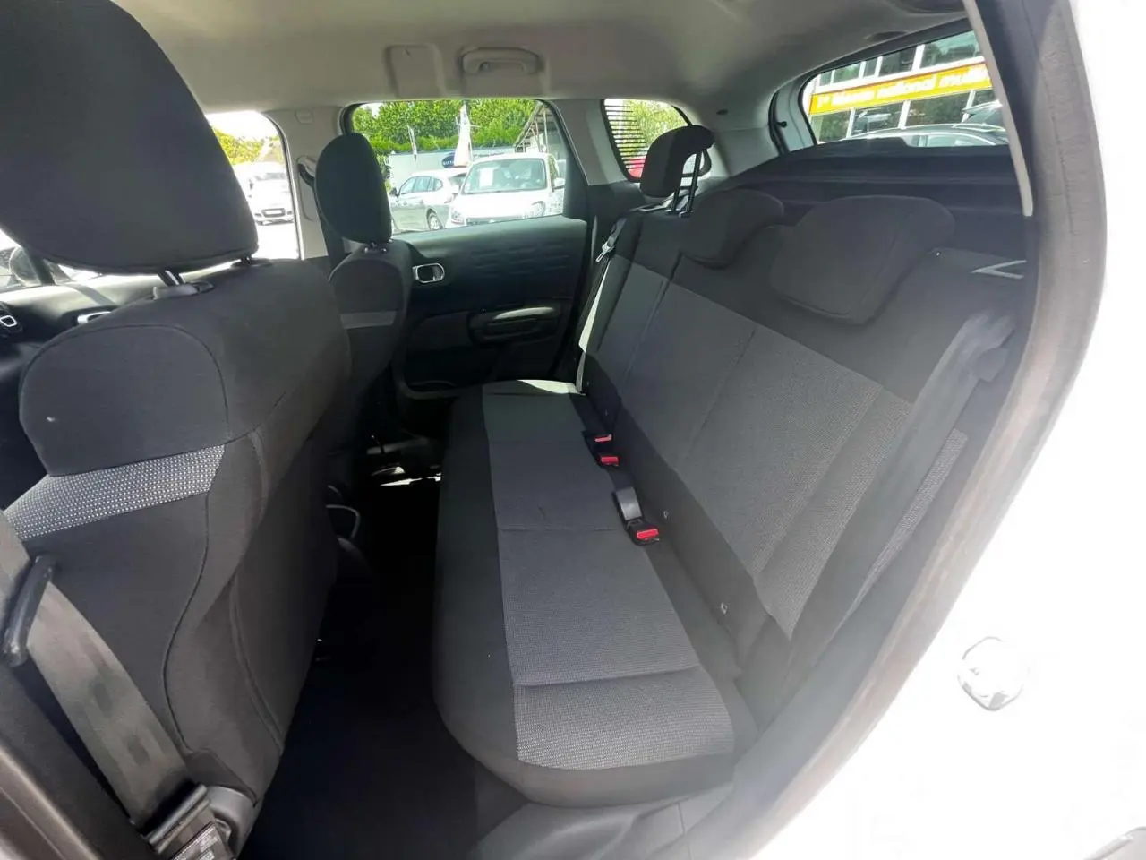 Vue intérieure côté droit montrant la banquette arrière noire du Citroën C3 Aircross blanc banquise 2023.