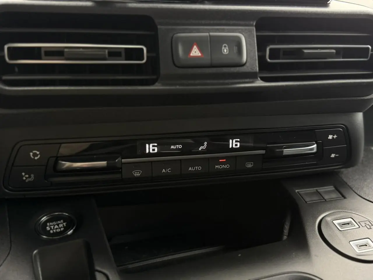 Détail intérieur du tableau de bord du Peugeot Rifter 2026, montrant la climatisation automatique bi-zone et le bouton start/stop.