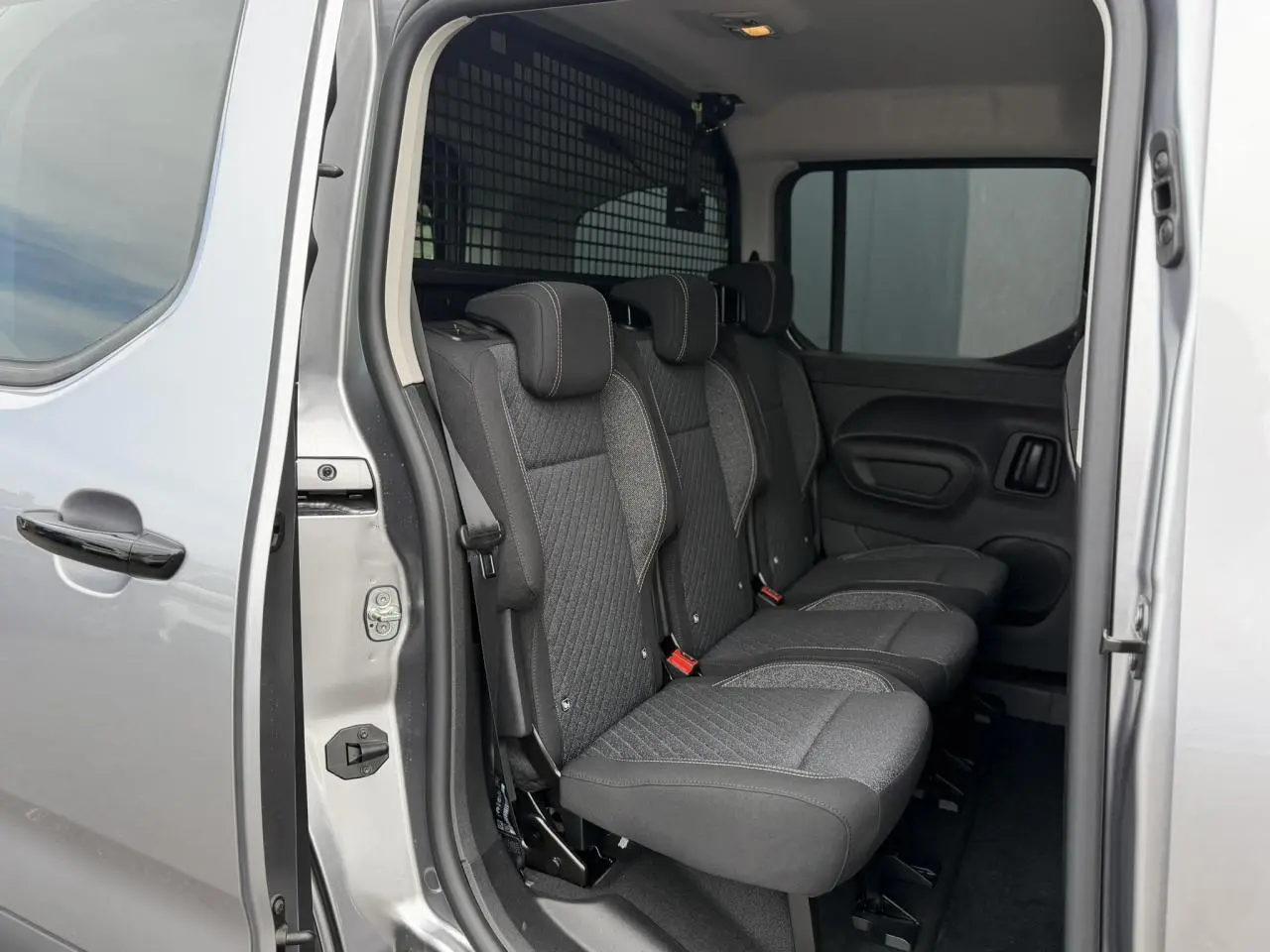 Vue intérieure côté gauche du Peugeot Rifter gris acier 2026, montrant les trois sièges individuels en rang 2.