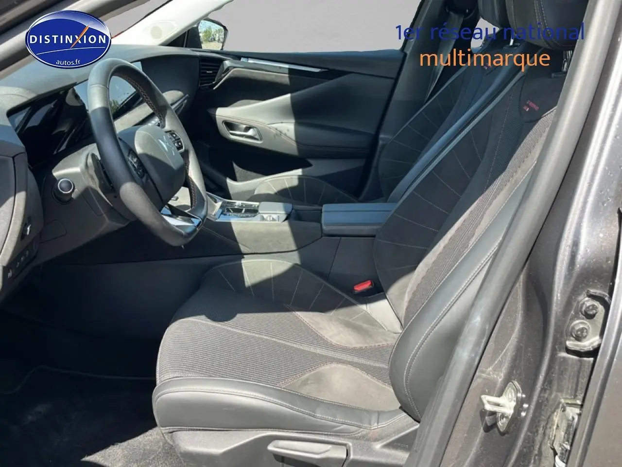 Vue intérieure côté conducteur du DS4 E-tense 225 gris platinium, avec sièges en alcantara noir et volant cuir.