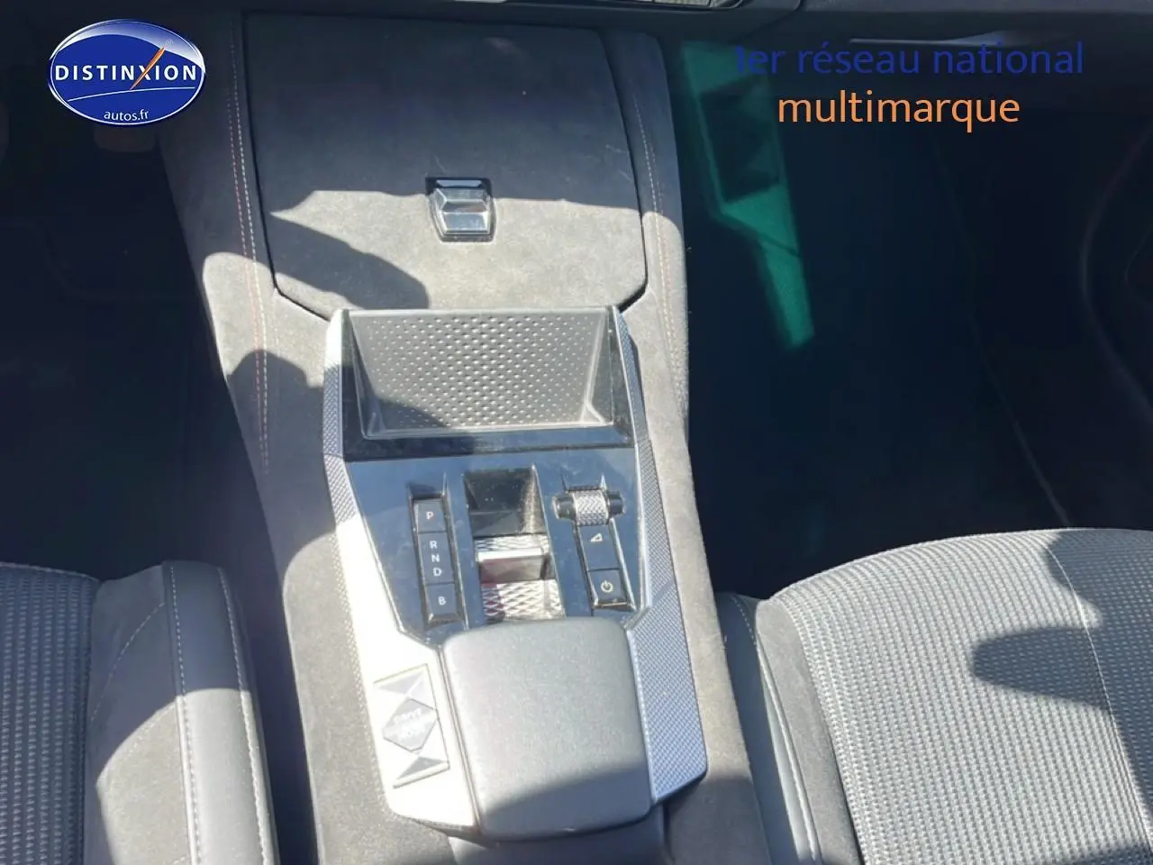 Vue rapprochée de la console centrale en alcantara noir du DS4 E-tense 225 gris platinium, avec levier de boîte automatique.