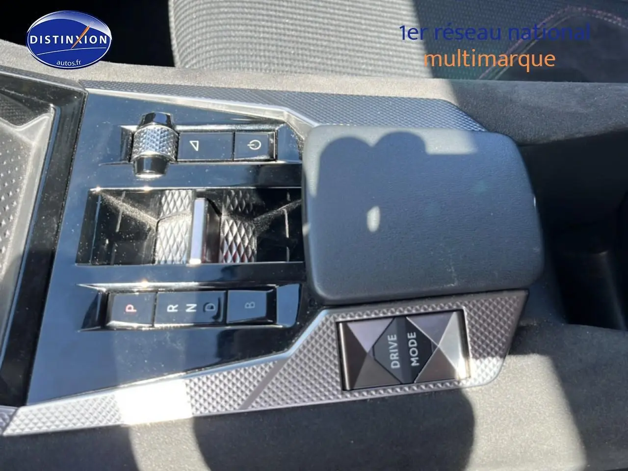 Gros plan sur la console centrale noire et grise du DS4 E-tense 225, avec sélecteur de boîte auto et bouton Drive Mode.