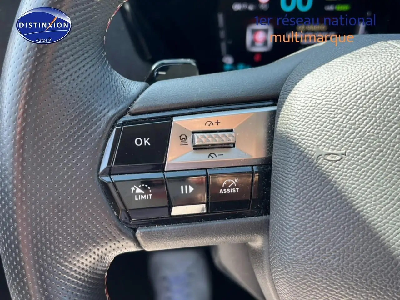 Gros plan sur les commandes au volant en cuir noir perforé du DS4 E-tense 225 gris platinium, avec boutons de régulateur et assistances.