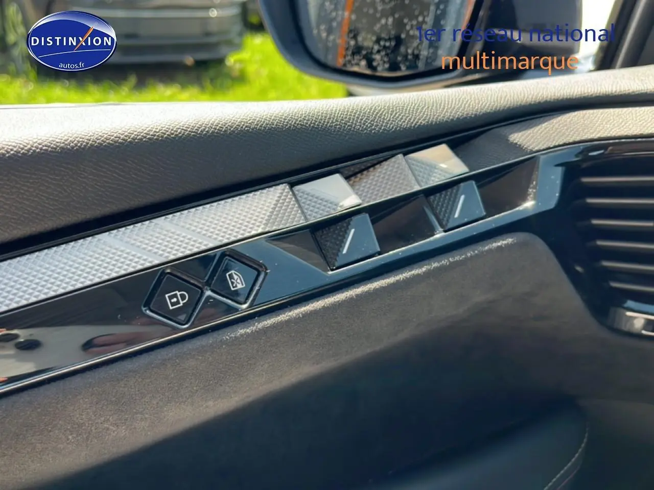 Détail intérieur côté conducteur du DS4 E-tense 225 gris platinium montrant les commandes de verrouillage et de vitres.